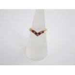 A 9ct gold diamond and ruby wishbone ring set with seven alternating stones, size M