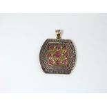 A 14ct gold pendant with pierced and scrolled detail set with nine rubies and twelve diamonds