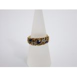 An 18ct gold ring set with alternating sapphires and diamonds (5) within a detailed setting, size M