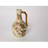 A Royal Worcester ivory ground jug with painted and gilded floral decoration