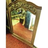 A wall mirror with bevelled edge plate within a moulded arched frame with applied scrolling acanthus
