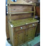 A stripped pine chiffonier, the raised back with shaped outline supporting two open shelves over a