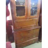 A mid 19th century continental stripped and waxed pine cabinet, the lower section enclosed by