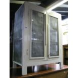 A vintage painted pine framed floor standing meat safe enclosed by a pair of doors with mesh panels