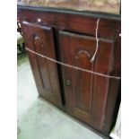 An antique chestnut side cupboard enclosed by a pair of fielded arched and moulded panelled doors
