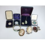 A small collection of jewellery to include two cameo brooches in unmarked white metal, an emerald