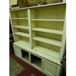 A 19th century painted pine two sectional bookcase, the upper two divisional section with adjustable