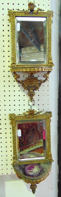A pair of small 19th century gilded wall brackets, each enclosing a bevelled edged mirror plate,