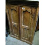 A small Indian hardwood side cupboard, freestanding and enclosed by a pair of twin panelled doors
