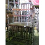 A Welsh folk art chair, the stained wooden frame with stepped arms and numerous cotton reel column