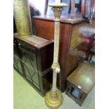 A lamp standard with carved and gilded base and head, the column with velvet upholstery