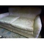 A two seat sofa with cream ground floral upholstery in the Howard style