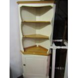 A contemporary freestanding pine corner cupboard, partially cream painted, the lower section