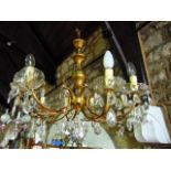 A brass eight branch chandelier with cut glass drops and drip trays