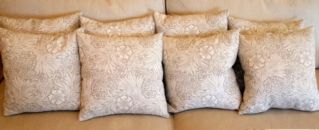 A collection of eight cushions in a William Morris fabric