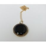 A 15ct gold Victorian black enamel and split pearl circular mourning pendant with 9ct gold link