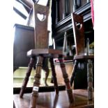 A pair of Arts and Crafts style walnut spinning chairs, the tapered backs with pierced heart-