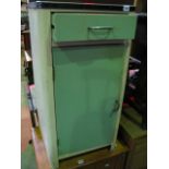 A vintage painted aluminium kitchen cupboard enclosed by a door beneath a drawer and enamelled top