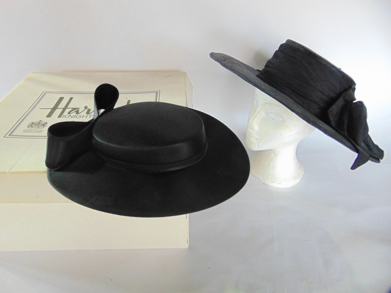 A Peter Bettley shallow medium brimmed ladies hat with bow, housed within a Harrods hat box,