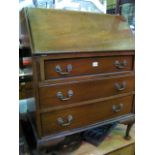 An Edwardian walnut bureau, the fall flap enclosing a simply fitted interior over three long