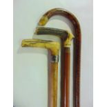 A short antique Malacca walking cane terminating in a worked handle together with a further timber