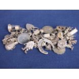 A sterling silver charm bracelet numerously set with sterling silver unmarked white metal charms,