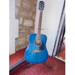 An Earthfire Summer Breeze acoustic guitar in a blue colourway number GA1000BL, complete with stand