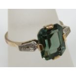 A 9ct gold ladies dress ring set with large emerald cut blue/green tourmaline in a four prong