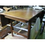 A mid 20th century teak dining table, the rectangular top with sliding action and single drop leaf