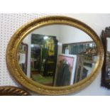 An oval gilt framed wall mirror with foliate banded surround, 106 x 74 cm approx
