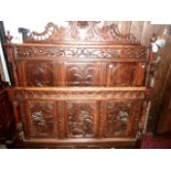 A 19th century Flemish walnut double bedstead, the panelled head and foot boards with carved