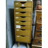 A small medium to light oak freestanding pedestal flight of eight filing drawers raised on simple