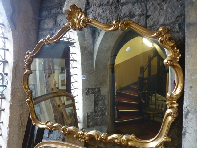 A wall mirror with decorative scrolling acanthus gilt frame with central shell surmount, 120 cm wide