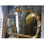 A wall mirror with decorative scrolling acanthus gilt frame with central shell surmount, 120 cm wide