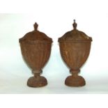 A pair of Regency style cast iron urns and covers, the bodies of fluted form with floral detail