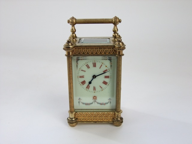 A late 19th century brass carriage clock, the casework with filigree and other detail enclosing a