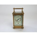 A late 19th century brass carriage clock, the casework with filigree and other detail enclosing a