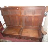 A 19th century oak settle with segmented panelled back over a box seat with hinged lid flanked by