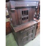 An old English style oak side cupboard, the lower section with quarter panelled door and frieze