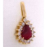 A ruby and diamond drop pendant centrally set with large pear drop shaped ruby surrounded by