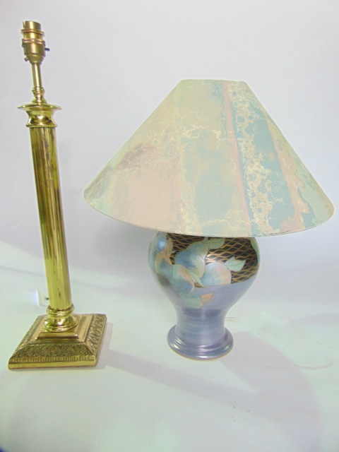 A brass table lamp with reeded column detail raised on a cast base, together with a further