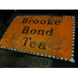 A vintage enamel sign of rectangualr form advertising Brooke Bond Tea, with orange ground and