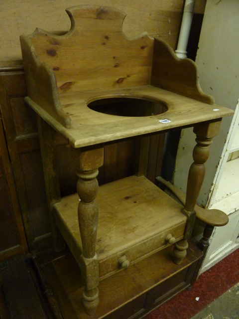 A Victorian style stripped pine washstand on two tiers, the upper with three quarter raised