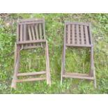 A pair of contemporary stained hardwood folding garden chairs with slatted seats and backs