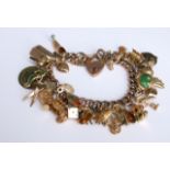 A 9ct gold charm bracelet with some 9ct charms and other unmarked yellow metal charms, 67g approx