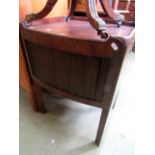 A Georgian mahogany bedside cabinet with bow fronted outline with tambour front and raised gallery