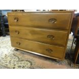 An Ercol light elm chest of drawers fitted with three long drawers on castors 66 cm high x 92 cm