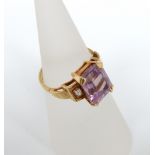 An 18ct gold amethyst and diamond ring, large emerald cut central amethyst in four prong setting,