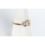 An 18ct gold three stone diamond crossover ring set with three old cut diamonds 2.7g, ring size O