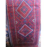 A Meshwari runner decorated with red medallions upon a blue ground, 57cm x 245cm